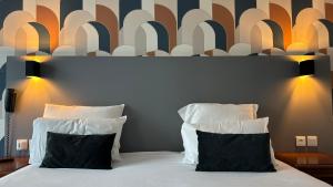 a bedroom with a large bed with two pillows at Hotel Le Bourgogne in Évian-les-Bains
