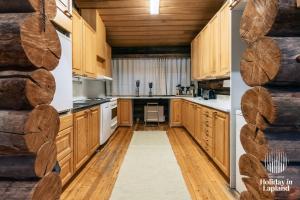una cucina con armadi in legno e pavimenti in legno di Holiday in Lapland - Ukonlammentie 11 a Kuusamo