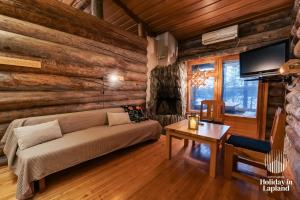 un soggiorno con un divano e un tavolo di Holiday in Lapland - Ukonlammentie 11 a Kuusamo Altre 17 foto