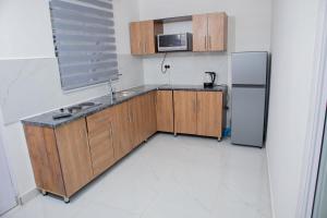a kitchen with wooden cabinets and a refrigerator at One Bedroom apartment A3 in Cape Town