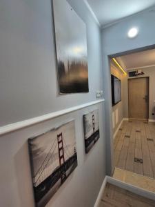a hallway with three pictures of the golden gate bridge at Central Apartment 2 bedrooms Business and Travel Lounge in Craiova +7 photos
