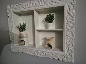 un miroir blanc avec des vases et des plantes. dans l'établissement HUGO Luxury Brand New 2 Bedrooms Apartment in the Center, à Craiova 1 autre photo