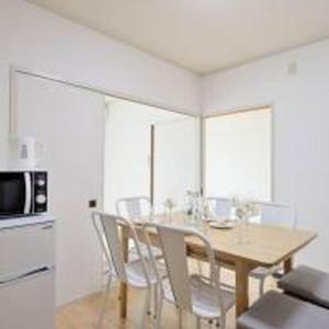 a dining room with a table with chairs and a microwave at City Heights Shinosaka 703 シティハイツ新大阪 703 in Osaka