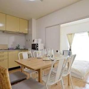 a kitchen with a wooden table and white chairs at City Heights Shinosaka 703 シティハイツ新大阪 703 in Osaka +27 photos