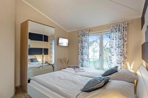 a bedroom with a large bed and a window at Wellness - Ferienhaus Steilküste in Fehmarn