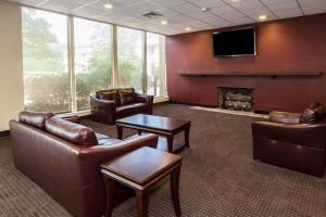 a waiting room with leather furniture and a flat screen tv at Days Inn by Wyndham Williamsport in Williamsport