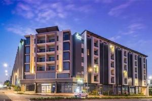 a large building with a car parked in front of it at Urban Park Umhlanga Rocks J001 in Durban