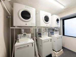 a room with four washing machines on a shelf at SUPER HOTEL Ikebukuro West Natural Hot Spring in Tokyo