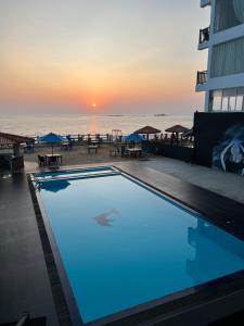 a swimming pool in front of the beach at sunset at Sevonra Beach Resort in Unawatuna