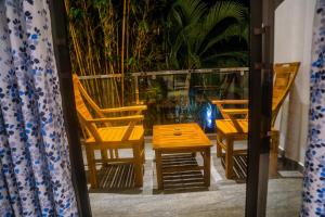 a pair of chairs and a wooden table and stool at Mirissa Breeze in Mirissa