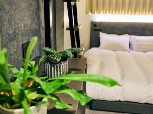 ein Schlafzimmer mit einem Bett und einem Tisch mit Pflanzen in der Unterkunft HOTEL ALL IN TOKYO Asakusabashi in Tokio