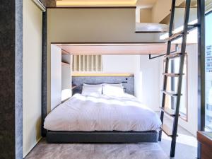ein Schlafzimmer mit einem Etagenbett und einer Leiter in der Unterkunft HOTEL ALL IN TOKYO Asakusabashi in Tokio