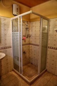 La salle de bains est pourvue d'une douche avec une porte en verre. dans l'établissement Mahaweli View Bungalow, à Kandy