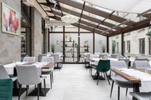 a restaurant with white tables and chairs at Golden Tulip Krakow City Center in Kraków