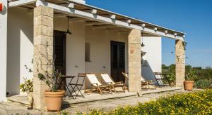a patio with chairs and tables on a house at B&B Sosta A Ponente in Matino