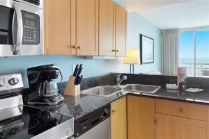 a kitchen with a sink and a stove top oven at Modern Decor Stunning Ocean View Condo Sleeps 8 in Myrtle Beach
