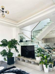 a living room with a tv and some plants at Say Homestay - Venuestay in Da Thien