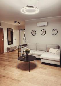 een woonkamer met een bank en een tafel bij Finezja Apartment with private parking in Toruń