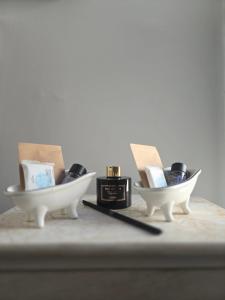 twee witte kommen met schoenen en een fles parfum bij Feel's Like Home Apartment in Chios