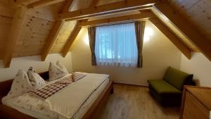 Un dormitorio con una cama y una ventana y una silla. en Siedls Enzian, en Hirschegg Rein 18 fotos más