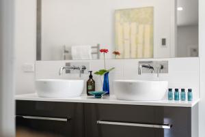 two sinks on a counter in a bathroom at Seagrass Studio Guesthouse - By the Beach in Tairua
