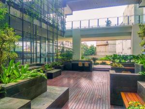 デポックにあるComfort 1BR Apartment at Evenciio Margonda By Travelioの植物とベンチのある建物のロビー