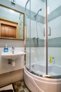 ein Bad mit einer Dusche, einem Waschbecken und einem WC in der Unterkunft LEOGRAND Apartments on Doroshenka 34 in Lwiw