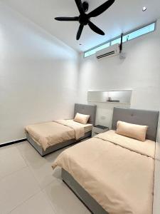 two beds in a room with a ceiling fan at Taiping CreekLodge - Modern BrandNew HomeStay in Kamunting +54 photos