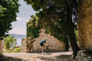 un hombre montando una bicicleta por un camino en Hotel Labineca, en Gradac