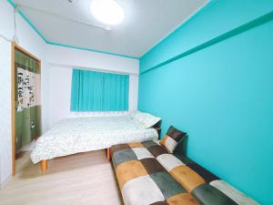 two beds in a room with blue walls at 403, Shinjuku Apt, Jr Yamanote Line, Jr山手线 高田馬場駅歩行5分 新宿 秋叶原 池袋 涩谷 六本木 上野直达 in Tokyo