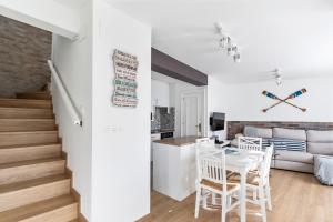 a living room and dining room with a white table and chairs at La terraza de ribadesella in Ribadesella