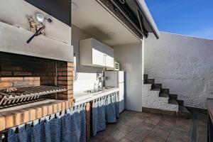 a kitchen with a stove and a sink and a staircase at La terraza de ribadesella in Ribadesella