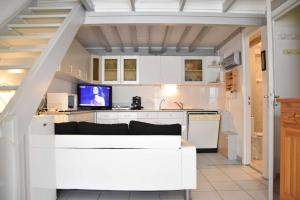 a kitchen with white cabinets and a white couch at Maison 4 pièces - Gruissan AY050-097 in Vires