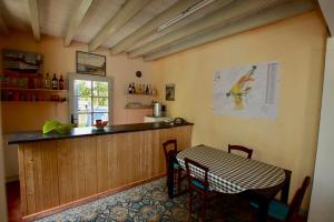 a kitchen with a counter and a table with chairs at DOMAINE de LA TAPIE in Bourriot-Bergonce