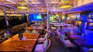 a restaurant with wooden tables and chairs and lights at Hideout Hostel 2 in Haad Rin