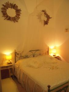 a bedroom with a bed with two lamps and two mirrors at Casa Santiago in Alassio