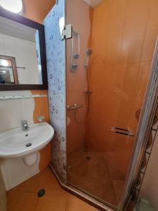 a bathroom with a shower and a sink at Къща за гости Билдникс in Malko Tŭrnovo