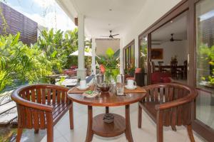 een eetkamer met een tafel en twee stoelen bij Villa Sedap Malam - Private 2 Bedroom Villa Near Seminyak Beach in Kuta