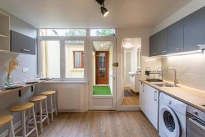 a kitchen with a sink and a door to a bathroom at L'Hortillon Amiens 4 pers 8min Centre ville & Gare in Amiens