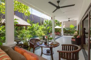 een woonkamer met een bank en een tafel bij Villa Sedap Malam - Private 2 Bedroom Villa Near Seminyak Beach in Kuta