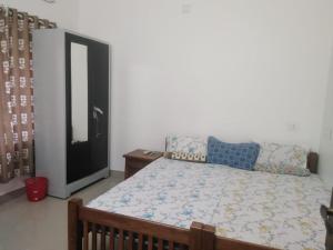 a bedroom with a bed and a dresser and a mirror at 2BHK Flat At Chalakudy Town Konuparamban Residence A1 in Kizhake Chālakudi