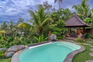 een zwembad in een tuin met een prieel bij Villa Kanwa in Tampaksiring