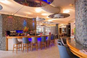 a bar in a restaurant with chairs and a counter at Metro Hotel Perth City in Perth