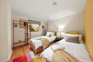 a bedroom with two beds and a window at Stylish Apartment in Euston and near Camden with Private Roof Terrace in London
