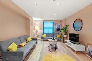 a living room with a couch and a tv at Stylish Apartment in Euston and near Camden with Private Roof Terrace in London