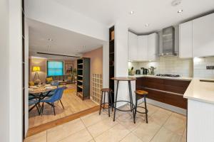 a kitchen and living room with a table and chairs at Stylish Apartment in Euston and near Camden with Private Roof Terrace in London