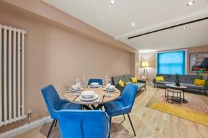 a dining room with a table and blue chairs at Stylish Apartment in Euston and near Camden with Private Roof Terrace in London +13 photos