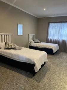 a bedroom with two beds and a window at Holiday Accommodation in Gqeberha
