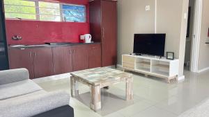 a living room with a tv and a coffee table at Holiday Accommodation in Gqeberha