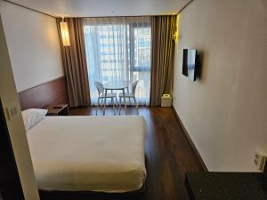 Postel nebo postele na pokoji v ubytování Tamara Jeju hotel